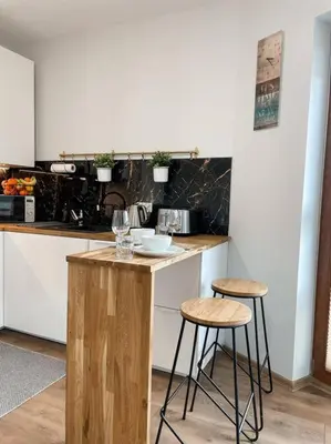 a kitchen with two bar stools and a counter top at New One Bedroom Apartment with balcony in Kraków