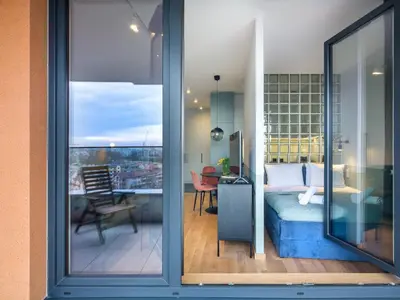 a room with a bed and a room with a balcony at Wislane Tarasy II by Tyzenhauz in Kraków