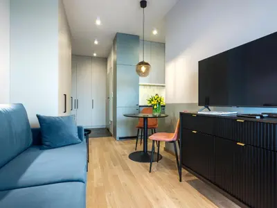 a living room with a blue couch and a table at Wislane Tarasy II by Tyzenhauz in Kraków