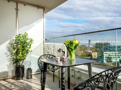 a table and chairs on a balcony with a view at Wislane Tarasy II by Tyzenhauz in Kraków