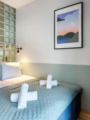 a bedroom with two beds and a picture on the wall at Wislane Tarasy II by Tyzenhauz in Kraków