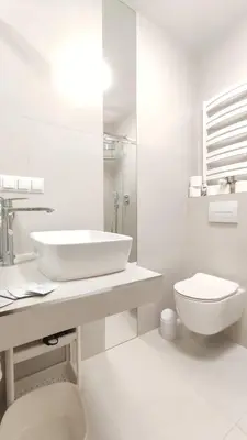 a white bathroom with a sink and a toilet at Szeroka 33 A-C by Homeprime in Kraków