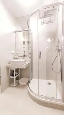 a white bathroom with a shower and a sink at Szeroka 33 A-C by Homeprime in Kraków