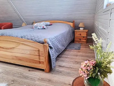 a bedroom with a wooden bed and a wooden floor at Chata Panorama in Stróża
