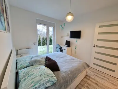 a bedroom with a bed and a television in it at Apartament ulica Lema - Tauron Arena Kraków, parking, WiFi in Kraków