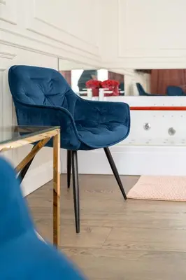 a blue chair sitting next to a glass table at Apartament z Jacuzzi Kraków GLAMOUR Starowiślna in Kraków