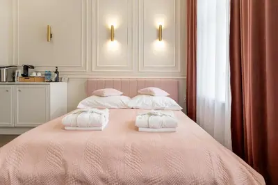 a bedroom with a pink bed with two pillows at Apartament z Jacuzzi Kraków GLAMOUR Starowiślna in Kraków