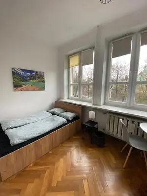 two beds in a room with windows at Classy Rooms in Old Town in Kraków