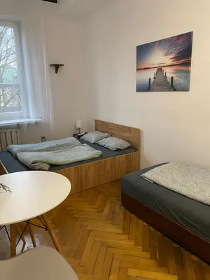 a room with two beds and a table in it at Classy Rooms in Old Town in Kraków