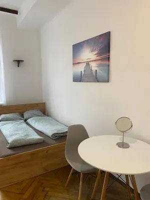 a bed and a table in a room with a table and chairs at Classy Rooms in Old Town in Kraków