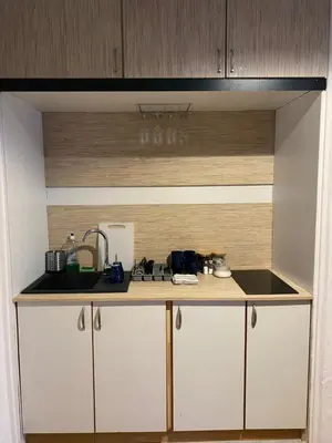 a kitchen with white cabinets and a counter top at Classy Rooms in Old Town in Kraków