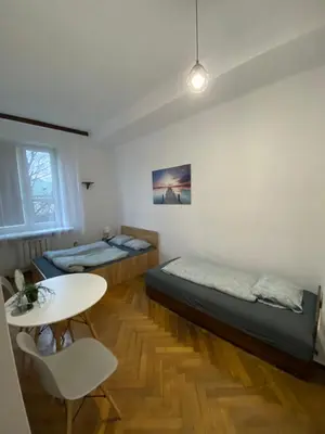a room with two beds and a table at Classy Rooms in Old Town in Kraków