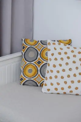 two pillows sitting on a bed next to a window at Saska Blu Studios Premium by Noclegi Renters in Kraków