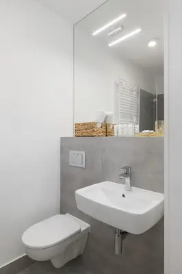 a bathroom with a sink and a toilet and a mirror at Saska Blu Studios Premium by Noclegi Renters in Kraków