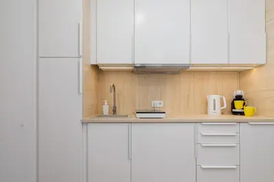 a kitchen with white cabinets and a sink at Saska Blu Studios Premium by Noclegi Renters in Kraków
