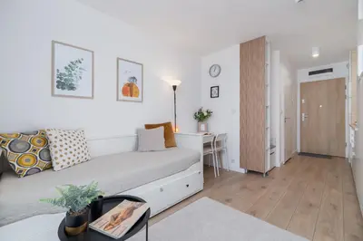 a white bedroom with a bed and a desk at Saska Blu Studios Premium by Noclegi Renters in Kraków
