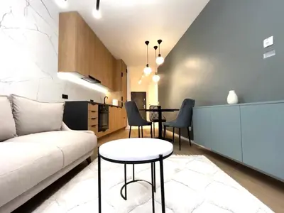 a bedroom with a bed and a desk and a window at Lovely Apartment in Kraków