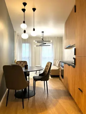 a kitchen and dining room with a table and chairs at Lovely Apartment in Kraków