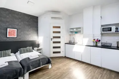 a kitchen with white cabinets and a bed in a room at Modern apartment in the very central location 20 in Kraków