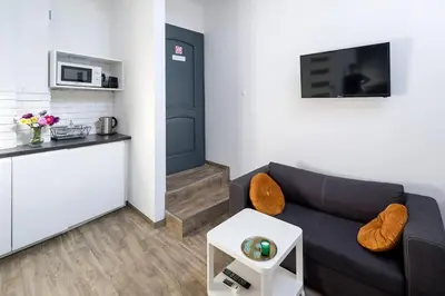 a living room with a couch and a kitchen at Modern apartment in the very central location 20 in Kraków