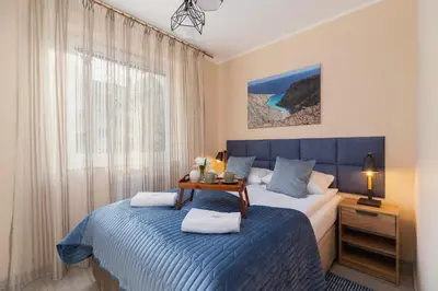 a bedroom with a bed with a blue blanket and a window at Business Apartment for Home Office Kołaczy Kraków by Noclegi Renters in Kraków