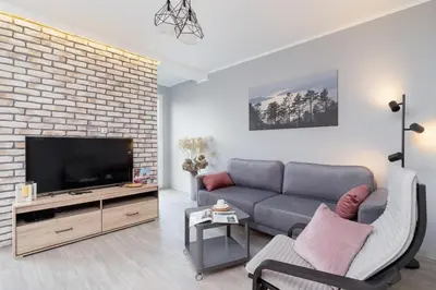 a living room with a couch and a tv at Business Apartment for Home Office Kołaczy Kraków by Noclegi Renters in Kraków