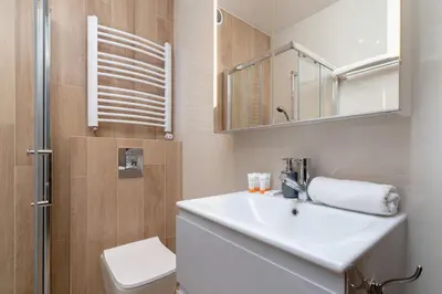 a bathroom with a sink and a toilet and a mirror at Business Apartment for Home Office Kołaczy Kraków by Noclegi Renters in Kraków