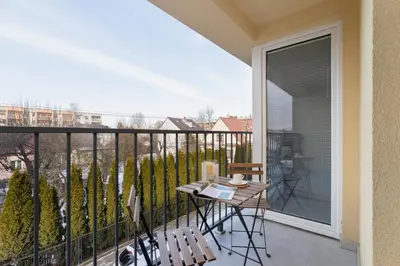 a balcony with a table and chairs and a window at Business Apartment for Home Office Kołaczy Kraków by Noclegi Renters in Kraków