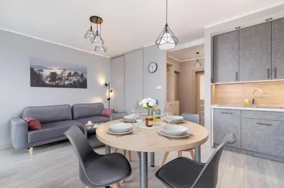a kitchen and a living room with a table and chairs at Business Apartment for Home Office Kołaczy Kraków by Noclegi Renters in Kraków