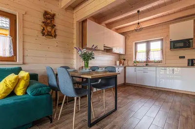 a kitchen and dining room with a table and chairs at Domki Gorczański Zakątek - Jacuzzi in Nowy Targ