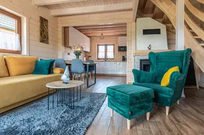 a living room with a couch and a table at Domki Gorczański Zakątek - Jacuzzi in Nowy Targ