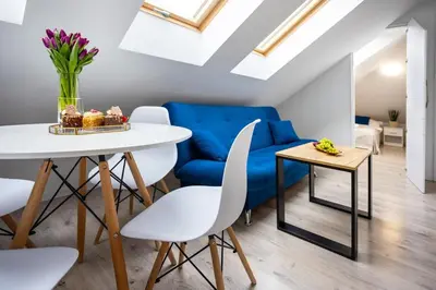 a living room with a white table and blue couch at Aleja 69 in Kraków