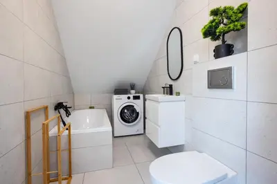 a bathroom with a washing machine and a washer and dryer at Aleja 69 in Kraków