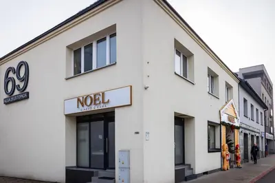 a white building with a noel sign on a street at Aleja 69 in Kraków