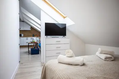 a bedroom with a bed with a flat screen tv at Aleja 69 in Kraków