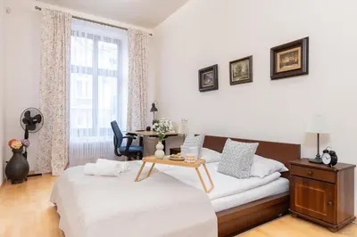 a bedroom with two beds and a table in it at Przytulnie i naturalnie — Balkon in Kraków