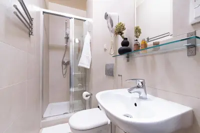 a bathroom with a sink and a shower and a toilet at Przytulnie i naturalnie — Balkon in Kraków