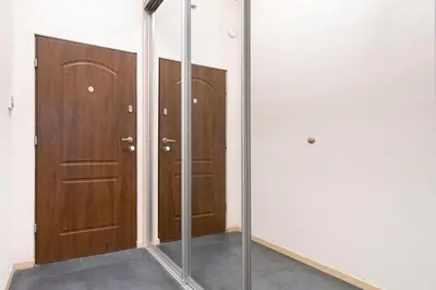 a room with two wooden doors and a mirror at Przytulnie i naturalnie — Balkon in Kraków
