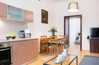 a kitchen and living room with a table and chairs at Przytulnie i naturalnie — Balkon in Kraków