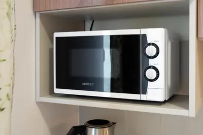 a microwave on a shelf in a kitchen at Przytulnie i naturalnie — Balkon in Kraków