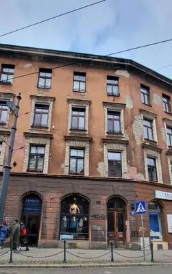 a large brick building with a dog in the window at Jacuzzi Kraków Bamboo in Kraków