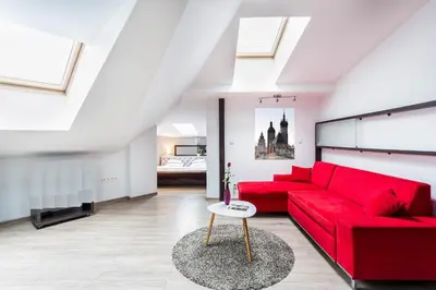 a red couch in a living room with skylights at Jacuzzi Kraków Bamboo in Kraków