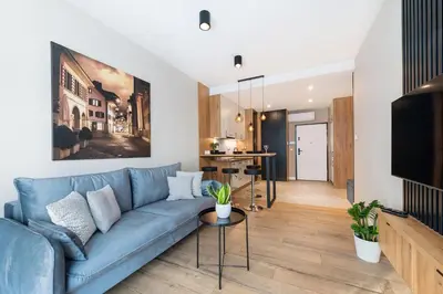 a living room with a blue couch and a tv at Krakowiak Apartment in Kraków