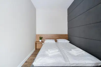 two beds in a room with white walls at Krakowiak Apartment in Kraków