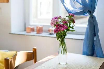 a vase filled with pink flowers sitting on a table at Sekretne gniazdko w tajemniczym ogrodzie in Kraków