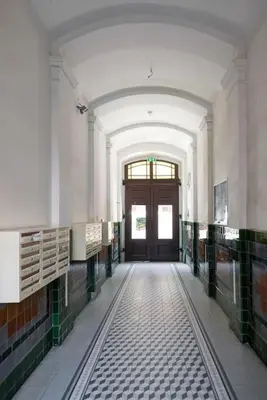 a hallway of a building with a door and tiled floors at Sekretne gniazdko w tajemniczym ogrodzie in Kraków
