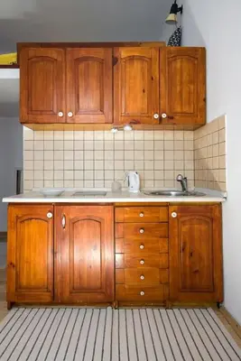a kitchen with wooden cabinets and a sink at Sekretne gniazdko w tajemniczym ogrodzie in Kraków