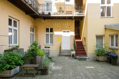 a courtyard of a house with a white door at Sekretne gniazdko w tajemniczym ogrodzie in Kraków