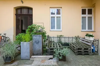 a patio with two wooden benches and a building at Sekretne gniazdko w tajemniczym ogrodzie in Kraków