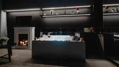 a bathroom with a tub and a fireplace with candles at Glamour Jacuzzi Apartment in Kraków